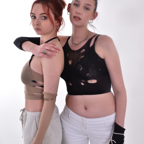 Photo of two females posing together, one has their arm around the others shoulders